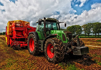Tractor pulling baler in field